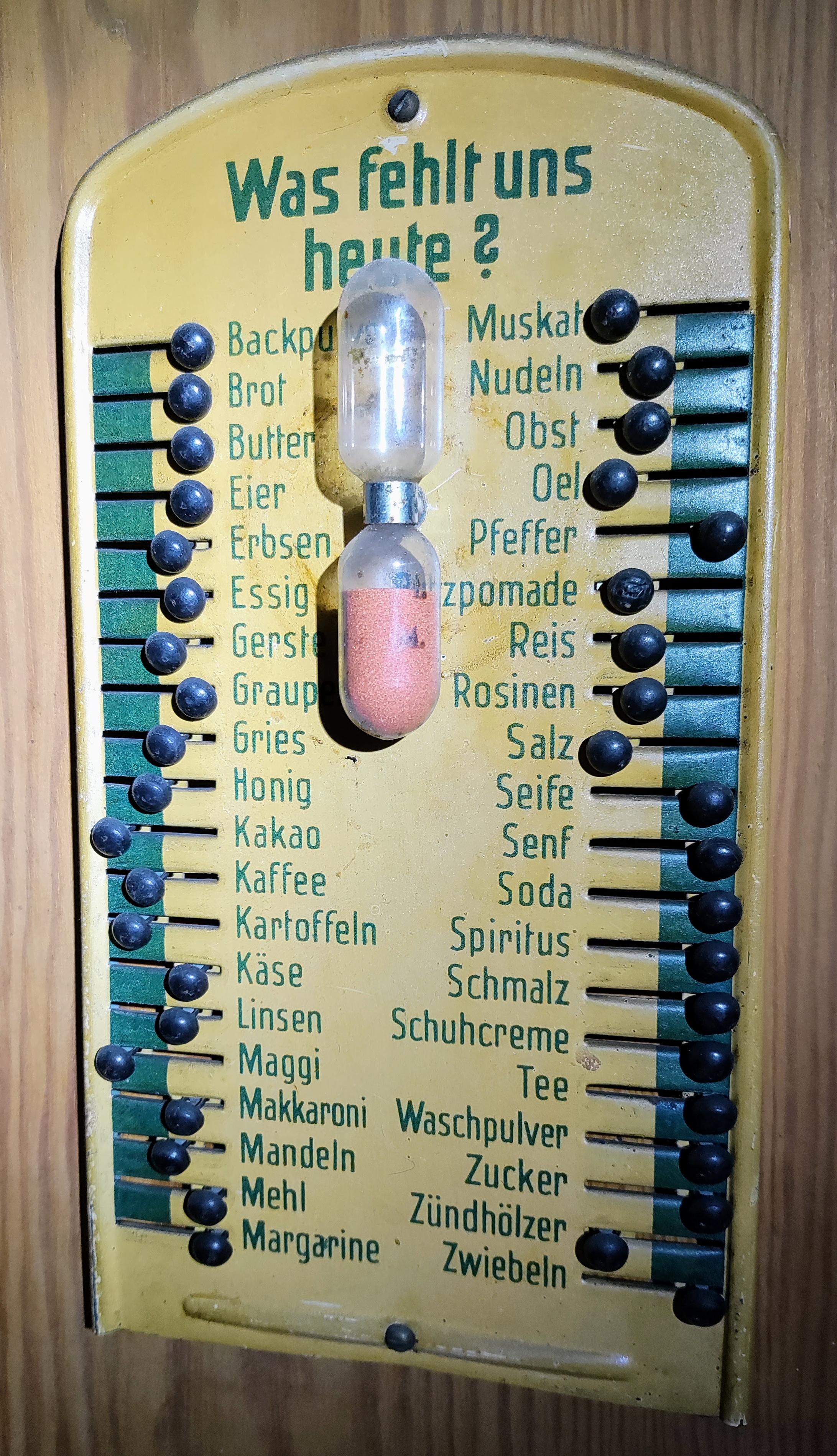 Blechschild mit verschiebbaren Perlen an Begriffen zu Haushaltswaren von Backpulver bis zwiebeln